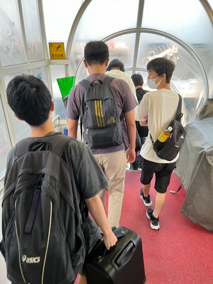 搭乗ブリッジを歩く生徒たち