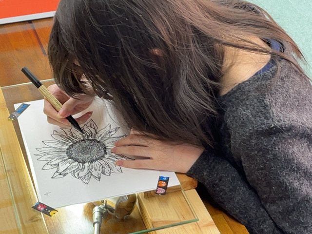 岐阜開成学院のアート講座でひまわりのペン画を描く生徒