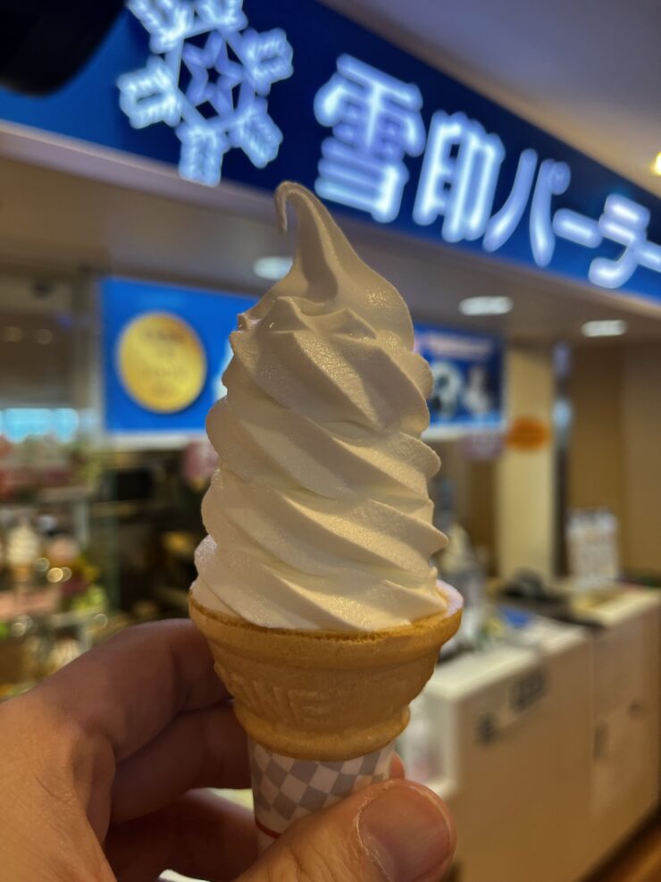 雪印パーラーの売り場前で手に持ったソフトクリーム