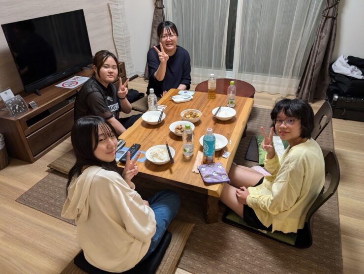 借り上げた一軒家の部屋で夕食を囲む生徒たち