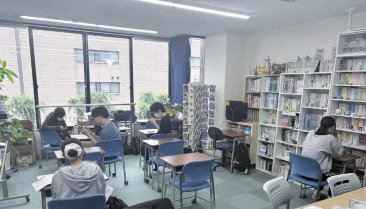 岐阜開成学院.の教室。窓辺と本棚に囲まれて、それぞれの席で学ぶ在校生たち