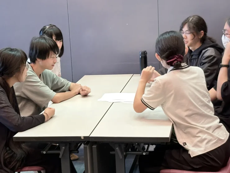 テーブルを囲んで話し合う生徒たち