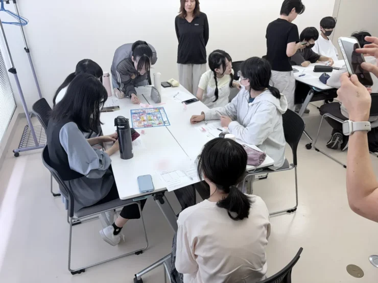 ボードゲームの盤面を囲んで、相談しながら進める生徒たち