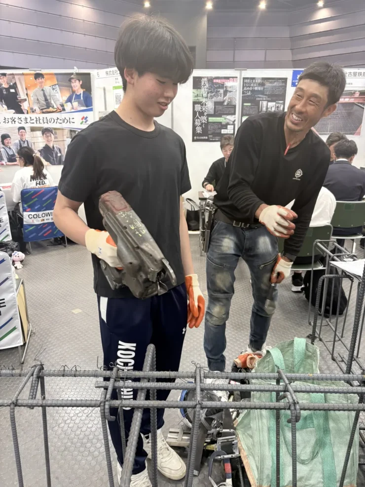 仕事フェアで、職人さんに教わりながら鉄筋作業を体験する生徒