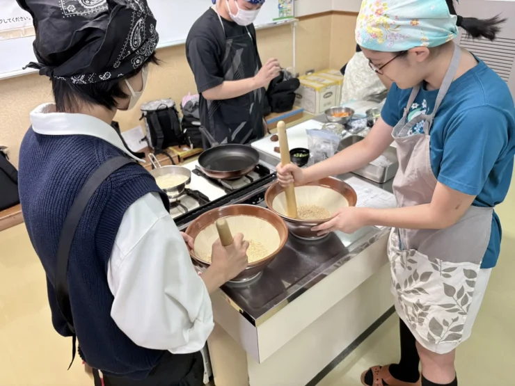 すり鉢でごまをすって、梅白ごまだれを作る生徒